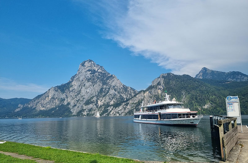 ots.at Tourismus Header Bild mit einer Wiese in den Bergen an einem sonnigen Tag
